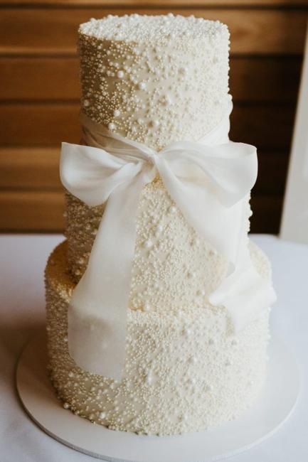 Wedding cake decorated with a bow and pearls